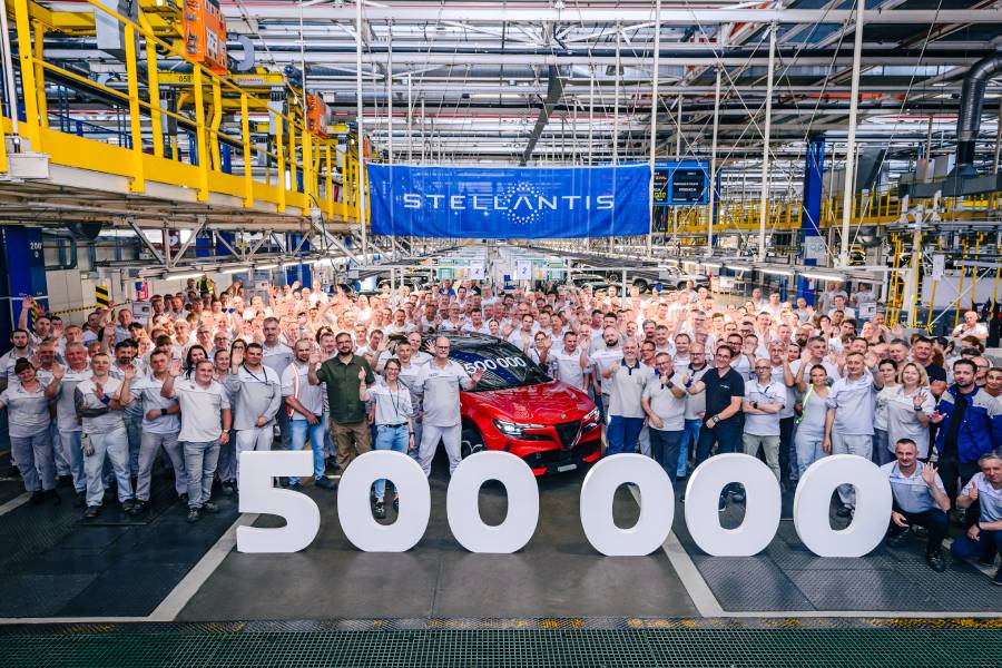 Funcionários ao lado de um Alfa Romeo Junior vermelho celebrando feito inédito