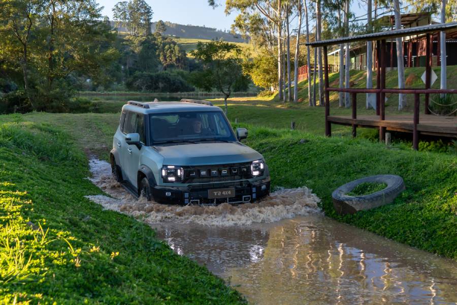 Jetour T2 4x4 verde fosco passando em trecho alagado