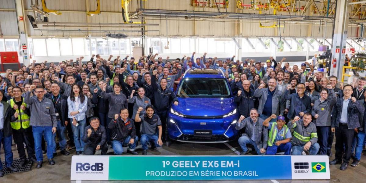 Funcionários reunidos ao lado do Geely EX5 EM-i fabricado no Brasil