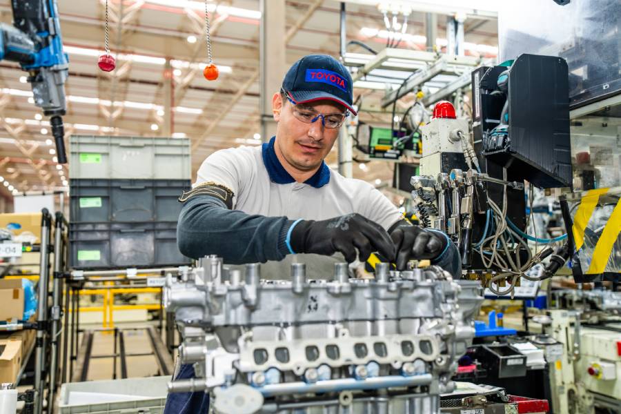 Funcionário mexendo em motor de carro da Toyota